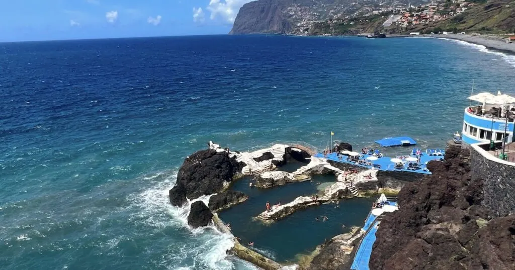Volcanic pools with blue platforms at sunset.
