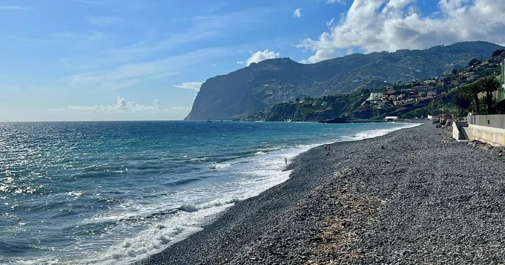 Pebbles at the Praia Formosa beach in Funchal, with Cabo Girao in the background.