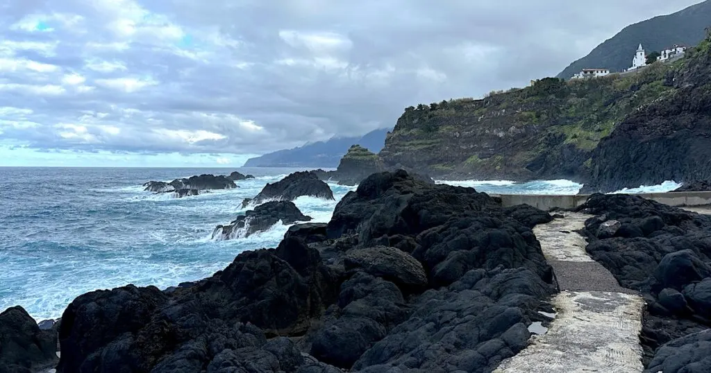 Pathway through black volcanic rocks next to the Seixal natural swimming pools.