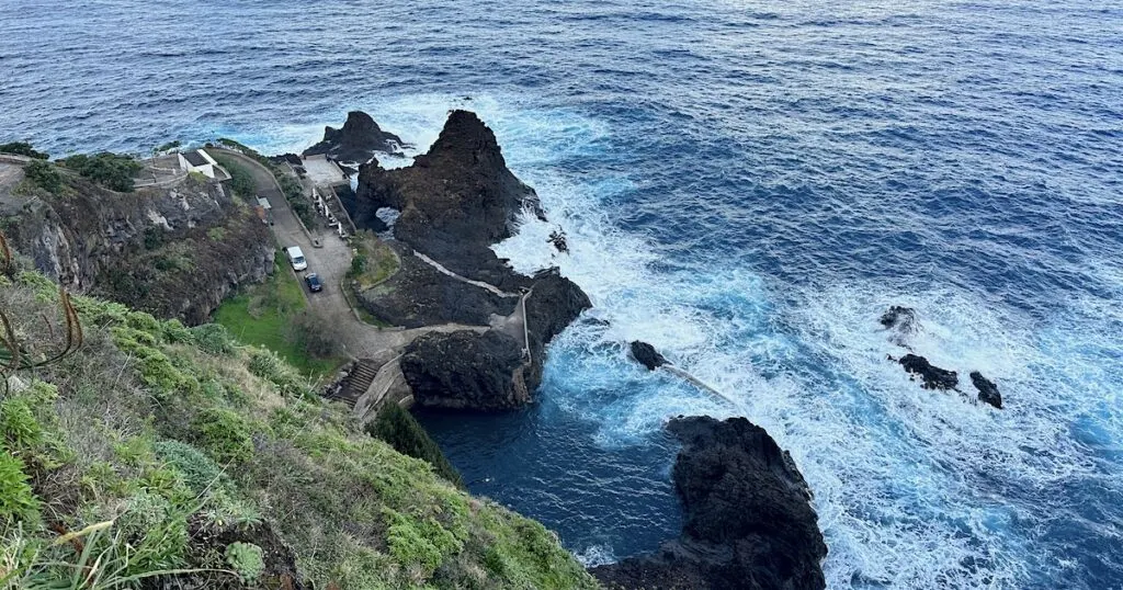Viewpoint over a grassy bank above the Seixal natural pools.