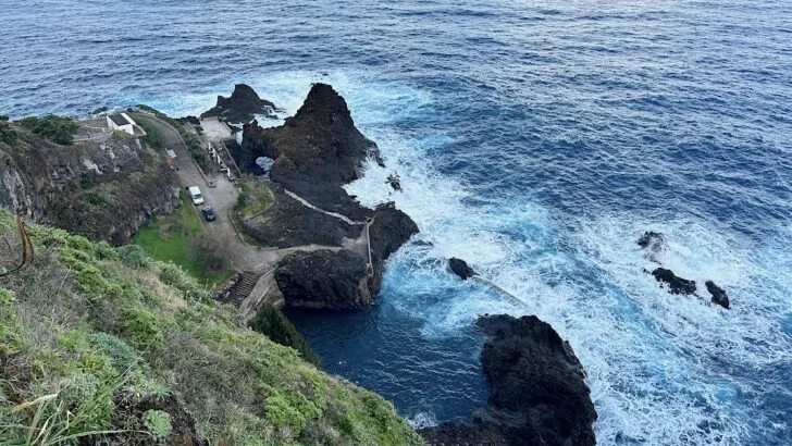 Viewpoint over a grassy bank above the Seixal natural pools.