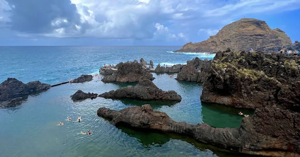 Jagged black volcanic rocks in the View over the Atlantic ocean from the Cachalote Natural Swimming Pools in Porto Moniz.