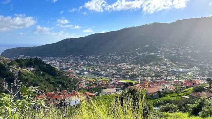 Terracotta tile roofs spread across a green valley in Machico.