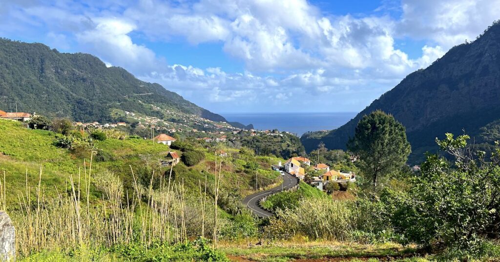 Winding road through a green valley towards Porta Cruz in Madeira.