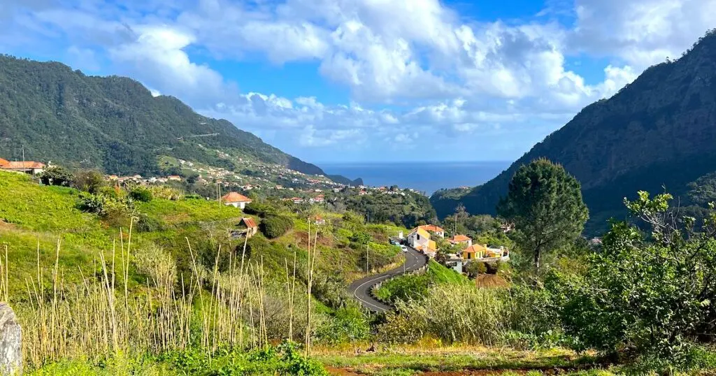 Winding road through a green valley towards Porta Cruz in Madeira.