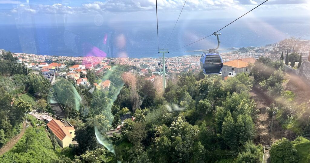 The Funchal cable car overlooking terracotta tiled houses and the ocean.
