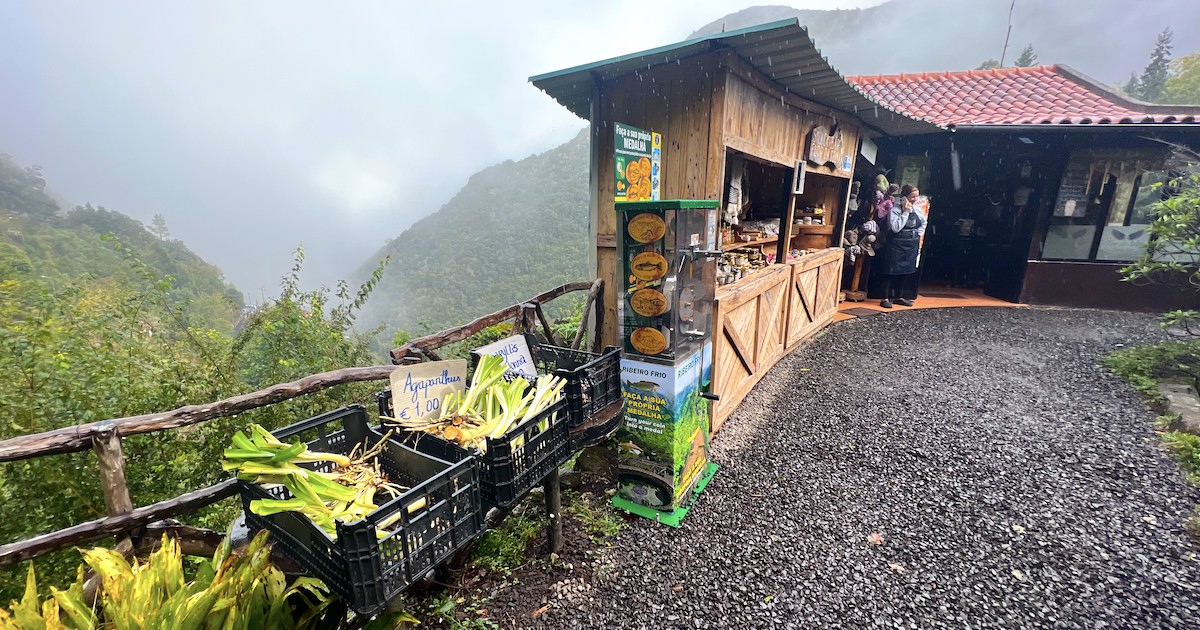 A narrow stall selling punnets of vegetables sits on the edge of a cliff on the Vereda dos Balcões trail in Madeira.