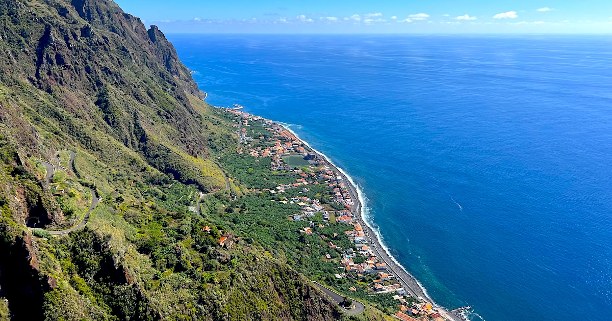 Steep, green cliffs slope down towards Calheta in Madeira.