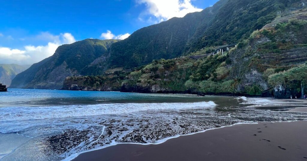 Waves lap the black sand at Seixal Beach.