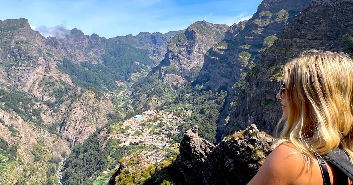 Woman overlooking the mountain village of Curral das Freiras surrounded by Madeira’s dramatic rocky peaks.