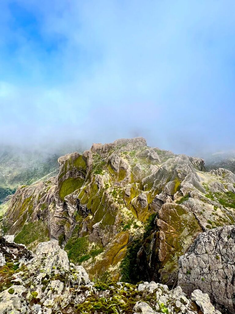 Rocky ridge near the summit of Pico Grande with clouds clearing around the surrounding peaks.