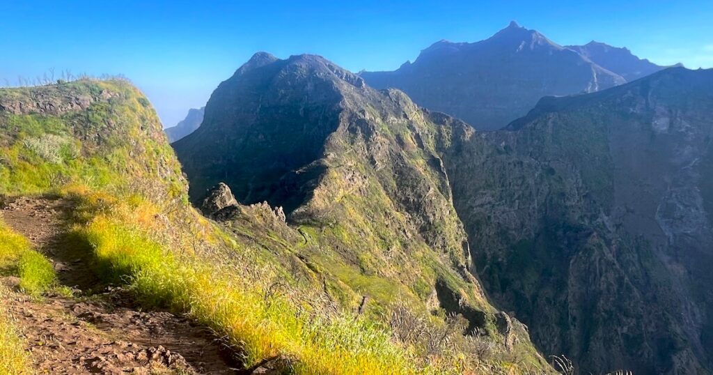 View from a mountain ridge across dramatic volcanic cliffs and deep valleys in Madeira.