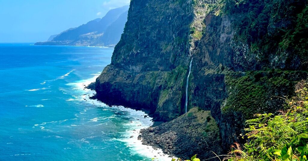 Waterfall cascading down a sheer coastal cliff into the Atlantic Ocean along Madeira’s dramatic shoreline.