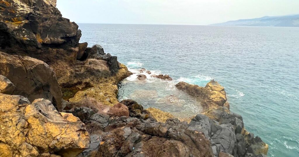 Seawater washing into a rocky pool beside the coast at Ponta de São Lourenço.